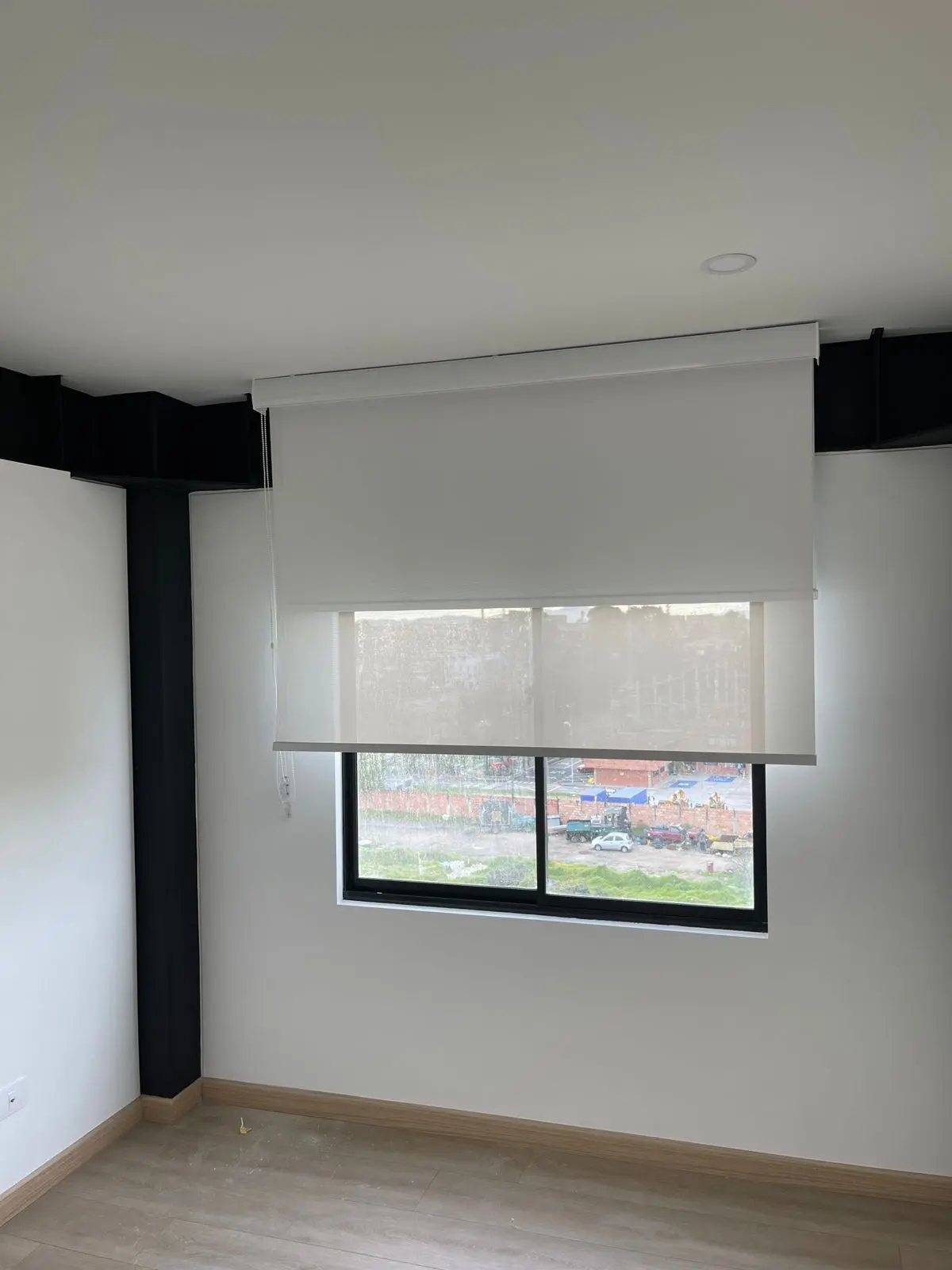 Cortina dual blanca instalada sobre una ventana de habitación