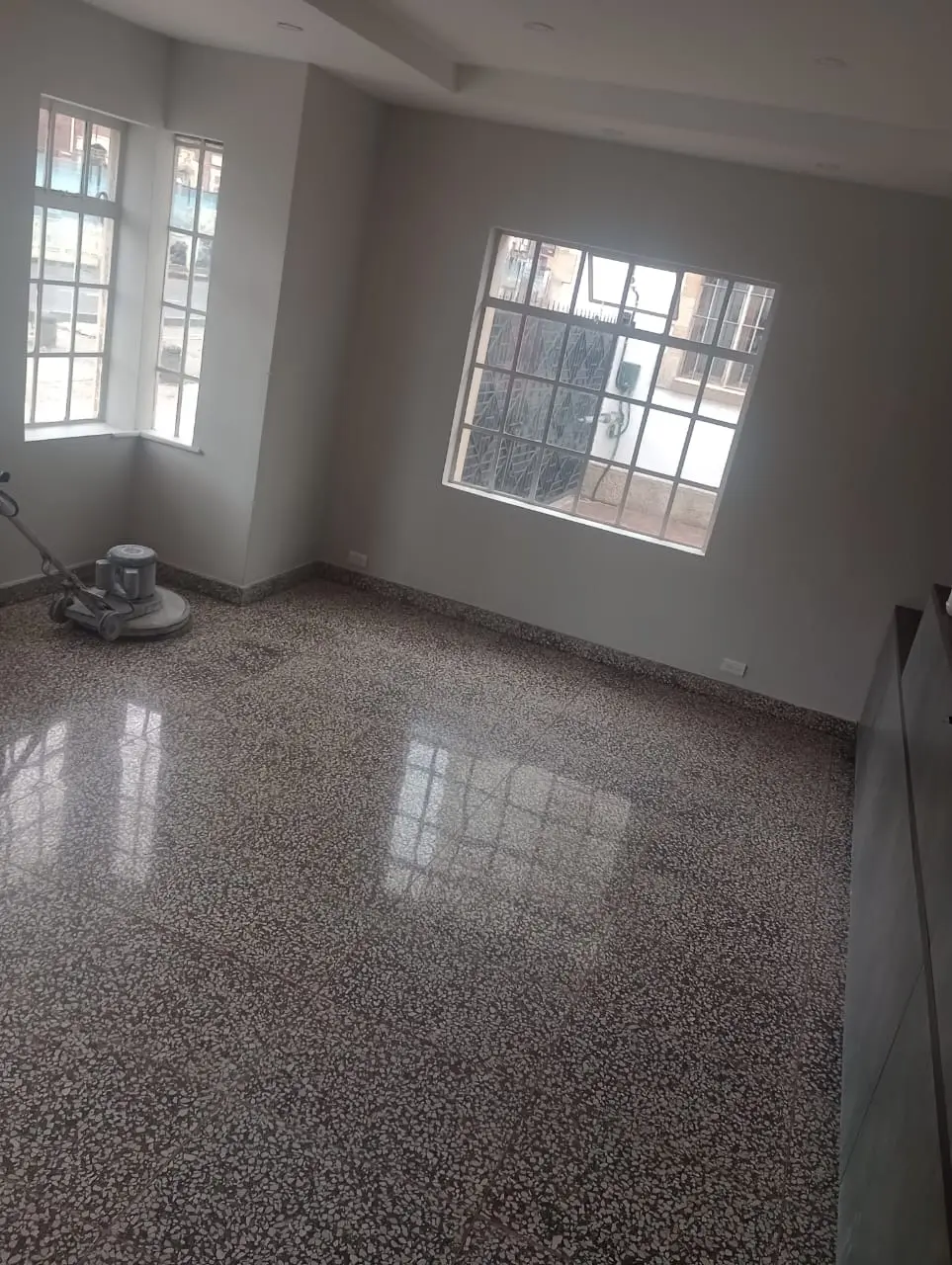 Piso de granito durante el proceso de pulido con una máquina industrial
