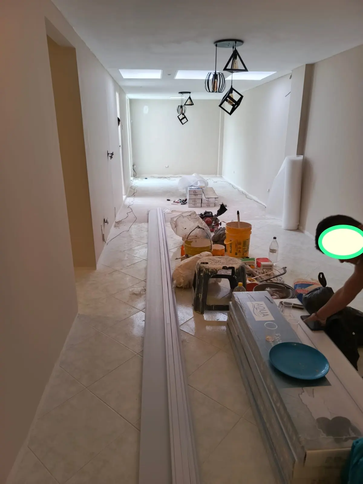 Salón durante la instalación de un nuevo piso, con materiales y herramientas de trabajo